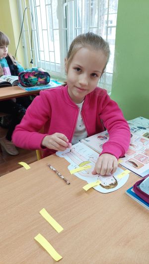 Dzieci siedzące w ławkach wykonując