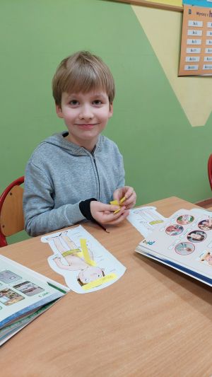 Dzieci siedzące w ławkach wykonując
