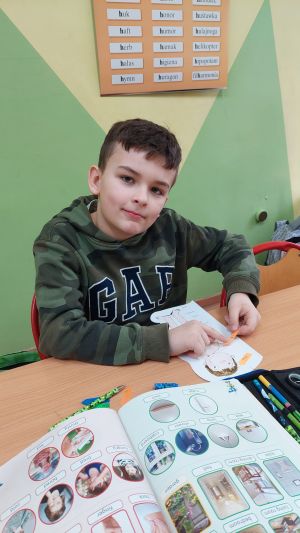 Dzieci siedzące w ławkach wykonując