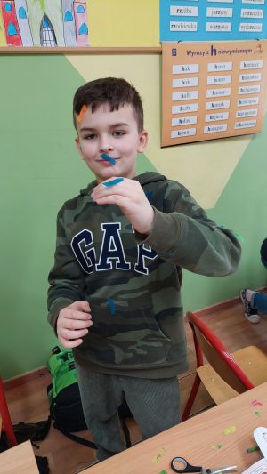 Dzieci siedzące w ławkach wykonując