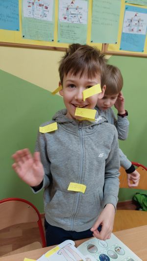 Dzieci siedzące w ławkach wykonując