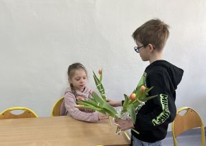 Chłopcy wręczający tulipany dziewczynkom.