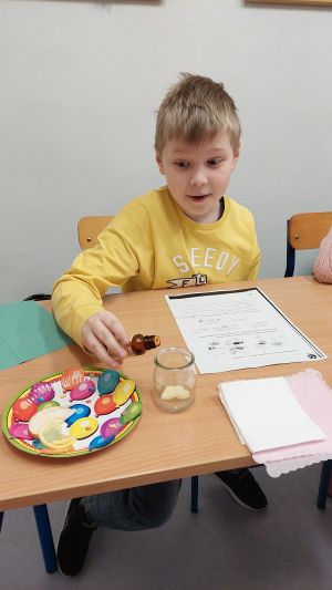 Uczniowie siędzą w ławkach i wykonują eksperymenty