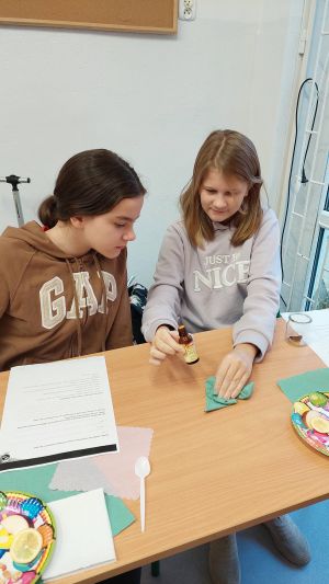 Uczniowie siędzą w ławkach i wykonują eksperymenty