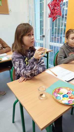 Uczniowie siędzą w ławkach i wykonują eksperymenty