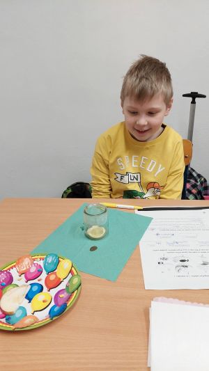 Uczniowie siędzą w ławkach i wykonują eksperymenty