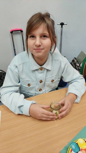 Uczniowie siędzą w ławkach i wykonują eksperymenty