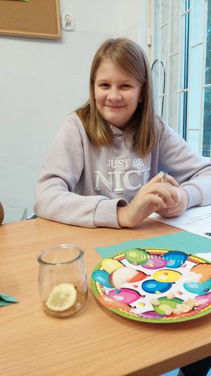 Uczniowie siędzą w ławkach i wykonują eksperymenty