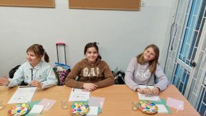 Uczniowie siędzą w ławkach i wykonują eksperymenty