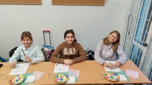 Uczniowie siędzą w ławkach i wykonują eksperymenty