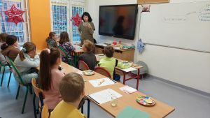 Uczniowie siędzą w ławkach i wykonują eksperymenty