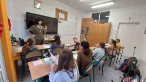 Uczniowie siędzą w ławkach i wykonują eksperymenty