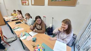 Uczniowie siędzą w ławkach i wykonują eksperymenty