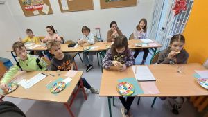 Uczniowie siędzą w ławkach i wykonują eksperymenty