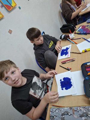 Uczniowie prezentujący swoją kleksografię